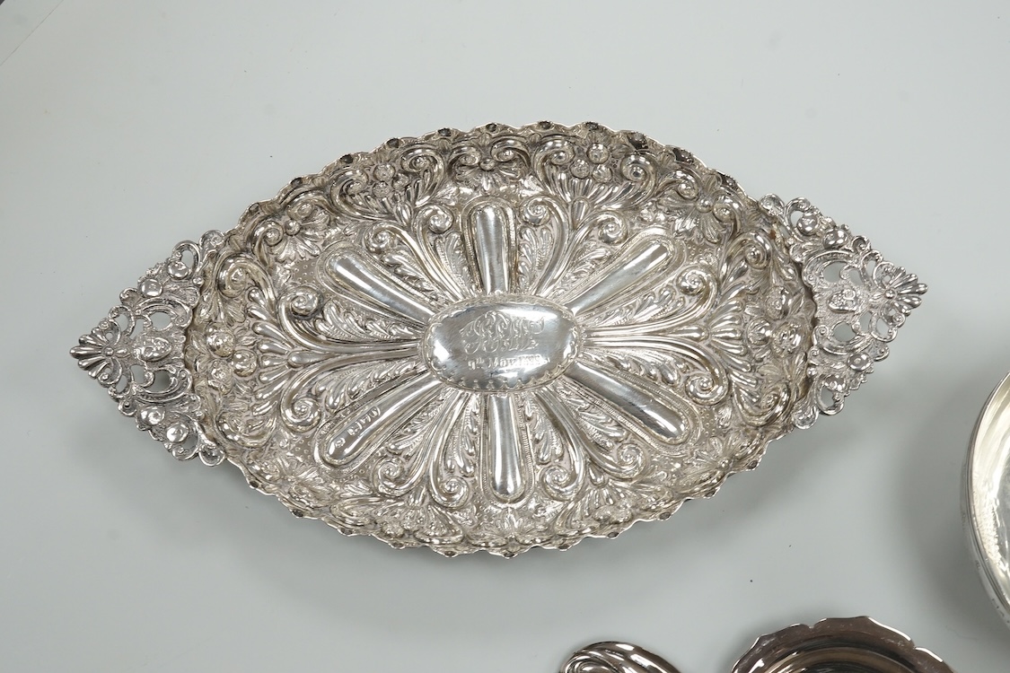 A late Victorian repousse silver navette shaped dish, by Charles Edwards, London, 1894, 25.7cm, with engraved monogram and date, together with a pair of mid 18th century silver sugar nips, an early 19th century silver vi